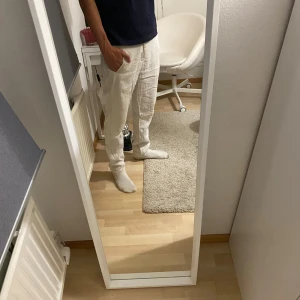 Beiga linnebyxor från Zara - Säljer ett par beiga linnebyxor från Zara med normal passform. Byxorna har klassiska fickor fram och bak, bälteshällor och stängs med knapp och dragkedja. Perfekta för varmare dagar och ger en chill och stilren vibe. Pris kan diskuteras!