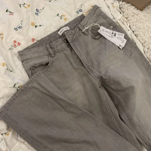 Grå baggy jeans från Gina tricot - Snygga ljusgrå jeans från Gina tricot i modellen low straight tall. Klassisk femficksdesign, raka ben och låg midja. Jeansen är i bomull och har en stilren look som passar till allt. Perfekta för dig som gillar en clean och enkel vibe.