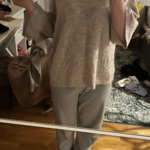 Beige stickad tröja med vida ärmar - Säljer en beige stickad tröja med riktigt sköna, vida ärmar. Tröjan har en loose passform och är perfekt för dig som gillar en chill och avslappnad stil. Materialet är mjukt och känns nice mot huden. Passar grymt till både jeans och mjukisbyxor.