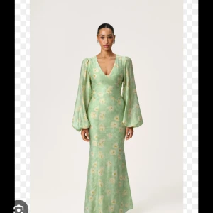 Grön blommig långklänning från Adoore - Aldrig använd då jag råka köpa fel storlek. Superfin grön långklänning från Adoore med ljusa blommor. Klänningen har v-ringning, puffiga långärmar och figurnära passform. Materialet är linne och ger en skön känsla. Perfekt för dig som vill ha en romantisk och trendig look.