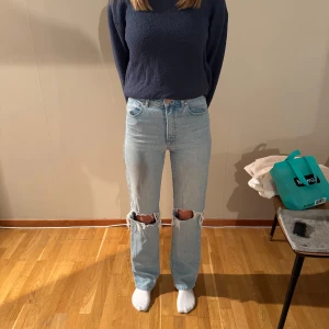 Abrand ljusblå ripped jeans straight - Säljer ett par ljusblå jeans från Abrand med raka ben och höga i midjan. Modellen heter '94 High Straight' och har snygga slitningar vid knäna. 