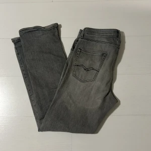 Grå jeans från Replay, rak modell - Säljer ett par grå jeans från Replay i rak passform. Jeansen har svarta sömmar och är tillverkade i mjukt denimtyg. Perfekta för dig som gillar en clean och stilren look.