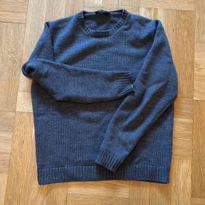 Stickad tröja från Zanone  - Säljer en snygg och stilren grå stickad tröja från Zanone inköp för närmare 4000 kronor. Perfekt att ha under en jacka nu under hösten och vintern. Tröjan har ribbade muddar vid ärmslut och nederkant. Passar både till vardags och lite finare tillfällen. Tröjan passar den som är runt 175