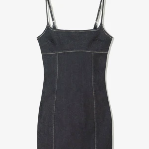 Bershka jeansklänning - Supersnygg marinblå kort jeansklänning med smala axelband och markerade sömmar. Klänningen har figurnära passform. Perfekt för dig som gillar en classy look. Helt oanvänd! Fortfarande prislapp kvar❤️skriv pris förslag