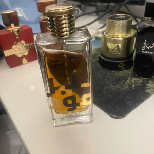 Lattafa Intense Oud parfym - Lattafa Intense Oud är en parfym i en stilren, rektangulär glasflaska med guldigt lock och arabiska bokstäver på framsidan. Doften har en djup bärnstensfärgad vätska som ger exklusiv känsla. Perfekt för dig som gillar orientaliska och kraftfulla dofter.