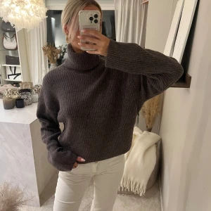 Brun ribbad polotröja från H&M  - Mysig brun ribbstickad polotröja från H&M i storlek XS. Tröjan har hög polokrage, lång ärm och en loose fit som ger en avslappnad vibe. Perfekt för lager-på-lager under kyliga dagar.