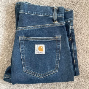 Blå jeans från Carhartt - Säljer ett par blå jeans från Carhartt med raka ben och normal passform. (HELT OANVÄNDA)