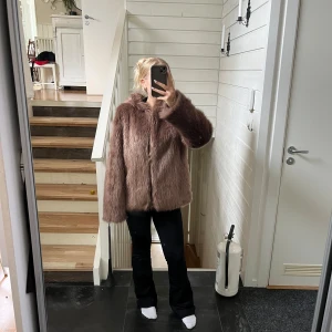 Brun fluffig pälsjacka med huva - Säljer en supermysig brun pälsjacka med huva. Jackan har en loose passform och är helt täckt av mjukt, fluffigt fuskpälsmaterial. Perfekt för dig som vill ha en varm och stylish look under höst och vinter. Långärmad och riktigt cozy vibe.