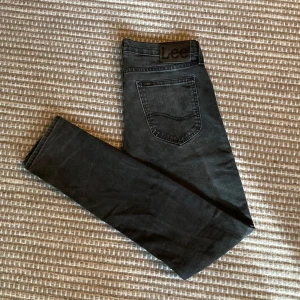 Svarta jeans Lee Luke - Snygga svarta jeans från Lee. Modellen Luke är slim fit. Jeansen är gjorda i mjuk bomullsblandning med lite stretch för extra komfort. Jag säljer nu flera Luke i samma storlek men olika färger!