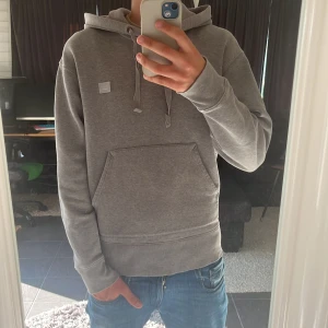Acne studio hoodie  - Säljer denna eleganta acne studio hoodie i storlek S, han på bilden är 1,80, acne är vanligvis ett väldigt dyrt märke och anledningen till att jag säljer denna så billigt beror på de lilla skadorna som ni ser på bilden. Hör av er vid minsta lilla fundering 