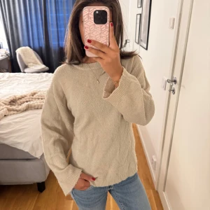 Beige stickad tröja från 157 XS - Mysig beige stickad tröja från 157 i storlek XS. Tröjan har rund hals, långa ärmar och ribbade muddar vid hals, ärmslut och nederkant. Perfekt för lager-på-lager och chill dagar. Enkel och stilren design som funkar till jeans eller kjol.💖