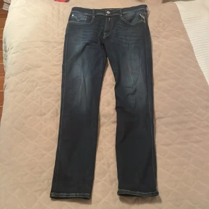 Replay Anbass slim jeans mörkblå - Snygga Replay Anbass jeans i mörkblå tvätt med slim fit och klassiska fem fickor. Tillverkade i återvunnet material för en modern vibe. Perfekta för dig som gillar stilrena och bekväma jeans.