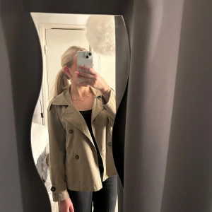 Grön Trenchcoat  - Grön kort trenchcoat från Stradivarius. Mycket fint skick och supersnygg