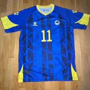 Bosnien Džeko #11 matchtröja Kelme L/M - Snygg blå fotbollströja från Bosnien och Hercegovina med Džeko och nummer 11 på ryggen. Helt ny har nt använt den pga av att den va för tajt på axlarna. Storleken e M men står L.