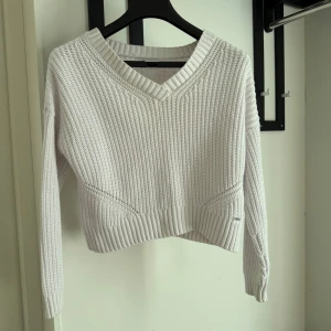 Vit stickad tröja från Hollister XS - Vit stickad tröja från Hollister i storlek XS. Tröjan har v-ringning, ribbade muddar och en croppad passform. 