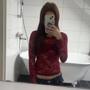 Vinröd spetsblus med lång ärm - Vinröd spetsblus som är ganska genomskinlig, men de funkar jättebra att ha tillexempel ett svart linne under! Jag skulle även säga att den sitter ganska tajt men den är i väldigt bra skick!