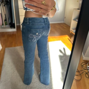 Blå bootcut jeans med pärldetalj - Säljer dessa jeans då de är lite för korta, jag är 166. Super snygga jeans med coola fickor.