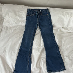 Blå bootcut jeans med låg midja - Snygga blå jeans med bootcut passform och låg midja.  Materialet är jeans i bomull med lite stretch för skön passform. Säljer för att de är för korta för mig. Jag är 174cm lång. Knappt använda pga det.