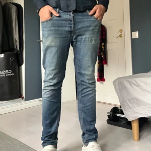 Blå slim jeans från Jack & Jones - Säljer ett par blå slim fit jeans från Replay med klassisk femficksdesign och snygga slitningar framtill. Jeansen har normal midja och raka ben med lätt tvättad look. Perfekta för dig som gillar en stilren och avslappnad vibe. Byxorna har inga hål me några naturliga slitningar tecken på användning. Skriv för fler bild etc!🙌strlk 30/32