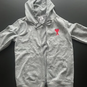 Grå hoodie från Ami Paris - Snygg grå zip-up hoodie från Ami Paris. Perfekt för chill dagar och streetstyle. Aldrig använd.
