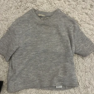 Grå stickad tröja från Gina Tricot - Kortärmad stickad tröja från ginatricot, nästan aldrig använd, xs men sitter som en S, nypris ca 350 