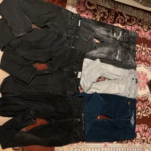 Mix av jeans i olika färger och stilar 100 kr st  - Flera par jeans i svart, grått, ljusgrått och mörkblått. Några har slitningar och detaljerade tvättar för en cool look. Modellerna varierar mellan skinny och straight fit. Perfekta för dig som vill ha olika stilar i garderoben.
