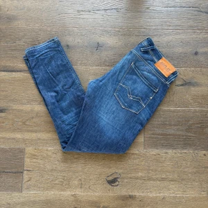 Blå Replay Anbass jeans slim fit - W32L32 Snygga blå Replay Anbass jeans med en klassisk framficksdesign. Jeansen har smal passform, normal midja och är i tunn denim. Finns en liten defekt men inget man märker. Hör av dig vid frågor 👍