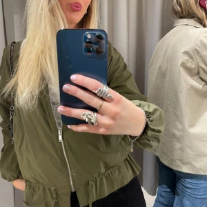 Grön jacka från Zara Basic - Säljer denna fina jackan från Zara Basic. Jackan har dragkedja framtill, resår vid ärmslut samt snörning i nederkant. Lätt och smidig modell i syntetmaterial, perfekt för lager-på-lager. Klassisk bomberstil med fickor på sidorna.