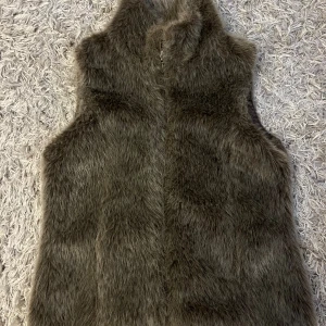 Grå pälsväst med dragkedja - Snygg grå väst med fakepäls.
