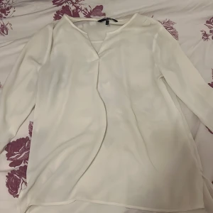 Vit blus från Vero Moda - Säljer en vit blus från Vero Moda i storlek S. Blusen har kort ärm, v-ringning och är tillverkad i ett lätt och luftigt material som ger en snygg och flowy look. Perfekt att matcha till allt. Hör av dig vid intresse!!