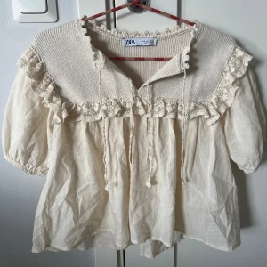 Trendig Zara blus med spets och volang  - Supersöt krämvit blus från Zara med stickad överdel, volangkant och broderade spetsdetaljer som inte säljs längre.💕💕 Endast använd 1-2 gånger och säljer just pga det. Nyskick, priset kan diskuteras. Köparen står för frakten. 