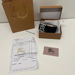 Burberry bälte  - Ett reversable burberry bälte vilket betyder att det går att vända den ut och in så du kan ha den i svart och i beige med silvrig logga i 105 cm, den är helt ny och allt i bilderna kommer med. Pris kan diskuteras och skriv om du har några frågor. 
