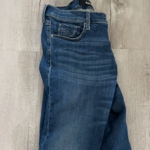 Replay blå jeans med klassisk tvätt - Snygga blå jeans från Replay med klassisk tvätt och diskreta slitningar. Jeansen har fem fickor, raka ben och tydliga sömmar. Perfekta för dig som gillar en tidlös och avslappnad stil. jeansen är uppsprättande där nere så kontakta mig om fler bilder osv