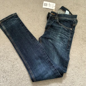 Dondup george slim jeans - Snygga mörkblå skinny jeans från George med klassisk femficksdesign och kontrastsömmar. Jeansen har en smal passform, normal midja och är tillverkade i slitstarkt denim. Perfekta för dig som gillar en tajt look och stilrena detaljer. Pris kan diskuteras vid snabb affär.