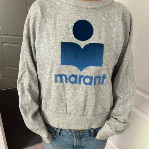 Grå sweatshirt Isabel Marant Étoile - Grå sweatshirt från Isabel Marant Étoile med stort blått logga framtill. Köpte i en av deras butiker i Frankrike. Helt äkta och snålt använd. Kontakta vid fler frågor
