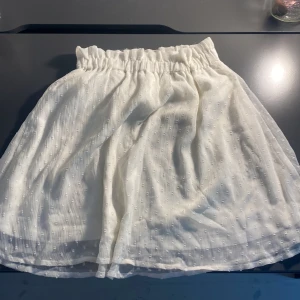 Vit kortkjol med strukturmönster - Vit kjol som aldrig använts.