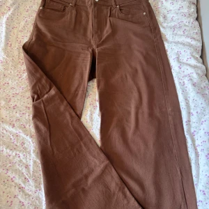Bruna jeans  - Midja 88cm, längd 104cm. Straight fit, hög midja. Bomull jeans. Säljer pga för stora, nopprar vid innerlåren. Behöver strykas men annars inga fläckar, hål eller knäskålar.