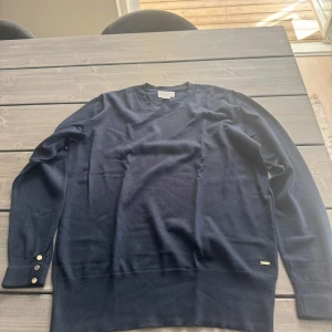 Mörkblå tröja från Holly & whyte - Snygg mörkblå tröja från Holly & whyte med rund halsringning och långa ärmar. Perfekt för lager-på-lager och stilrena outfits.