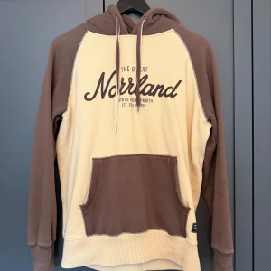Beige och brun hoodie från SQRTN Company - Säljer en beige och brun hoodie från SQRTN Company med trycket 'The Great Norrland' på bröstet.