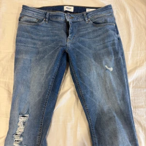 Lågmidjade jeans från only med hål  - Säljer ett par jätte fina lågmidjade jeans från only med hål .