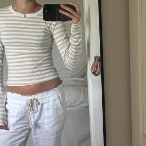 Beige och vit randig långärmad tröja H&M - Säljer en gullig långärmad tröja från H&M i beige och vitt randigt. Tight passform med rund halsringning och mjukt bomullsmaterial. Perfekt till jeans eller kjol💕det är en liten fläck på tröjan som man ser på bild tre, annars är tröjan i fint skick😊