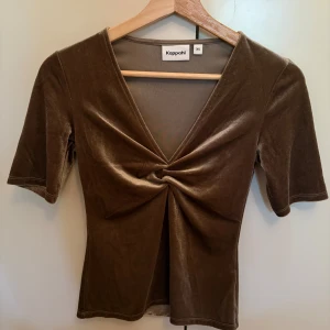 Brun sammetsblus från Kappahl XS - Supersnygg brun sammetsblus från Kappahl i storlek XS. Toppen är oanvänd.  Mjuk och glansig sammet gör den extra trendig och skön att bära. 