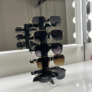 Fem par solglasögon med gulddetaljer - Säljer fem par trendiga solglasögon med fyrkantiga och lätt kantiga former. Alla har guldfärgade metallbågar och svarta skalmar. Glasen är tonade i svart, grått, brunt och blågrått. Perfekta för att lyfta din stil med en lyxig touch. Helt nytt skick har aldrig använts!