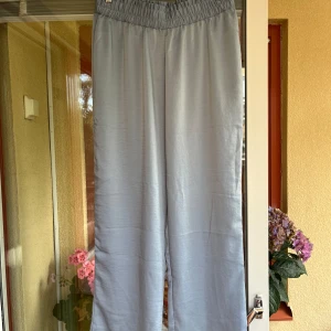 Ljusblå vida linnebyxor från Kappahl - Ljusblå pyjamasbyxor från Kappahl i storlek M. Byxorna har bred resår i midjan och raka, vida ben.