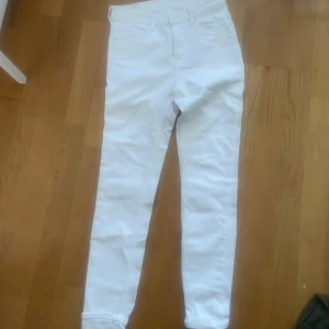 Vita skinny jeans - Snygga vita skinny jeans med klassisk femficksdesign och smal passform. Perfekta att matcha med en oversized hoodie eller en crop top. Byxorna har normal midja och är tillverkade i stretchigt bomullstyg för extra komfort.