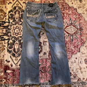 Miss me jeans - Jättefina missme jeans i storlek 28 men passar som 29. Fattar en knapp på baksidan och knappen framme är utbytt från förra ägaren. Den främsta skadan är vid den vänstra bakfickan som man kan se på bild 5. Dock har den förra ägaren sytt till tyg på insidan och det är igensytt- finns mer bilder att få. 