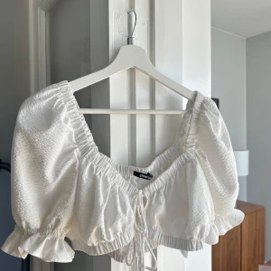 Vit croppad blus med puffärm - Supersöt vit croppad blus från Gina Tricot.