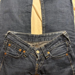 Levi's blå jeans Lågmidjade bootcut  - Super lågmidjade utsvängda jeans. Skicket är som nya, men tyvärr för små. Märket är Levi’s och är storlek 34.  Midjemått: 36cm Innerbenslängd: 72cm