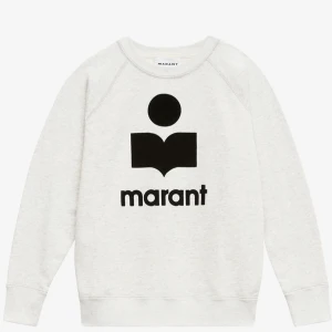 Vit/ljusgrå Isabel Marant sweatshirt - 3100 kr i nypris! Vit sweatshirt från Isabel Marant med svart logotyptryck framtill. Tröjan har rund halsringning, långa ärmar och en relaxed passform. Tillverkad i mjuk bomull som känns skön mot huden. Perfekt för en chill och stilren look.