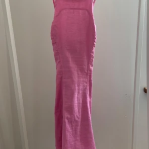 Rosa klänning från Gina Tricot - Supersnygg rosa kort klänning från Gina Tricot i linne. Klänningen har smala axelband, figurnära passform och dragkedja bak. Dessutom är klänningen helt oanvänd.